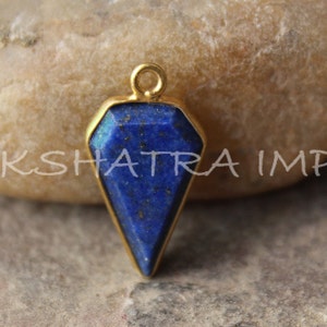 May include: Gold-plated pendant featuring a dark blue lapis lazuli gemstone in a faceted, pointed shape.