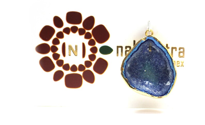 May include: A gold-plated pendant featuring a blue and green agate stone with a natural crystal formation. The pendant is on a white background with a logo that says "naktara".