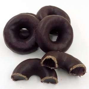 May include: A close-up of a pile of chocolate-covered jelly donuts. The donuts are arranged in a pile, with some of the donuts cut in half to show the jelly filling.