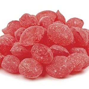 May include: A large pile of red, hard candy shaped like small, flat, oval-shaped discs. The candy has a slightly grainy texture.