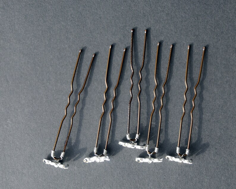 May include: Seven brown bobby pins with silver-colored ends. The bobby pins have a wavy design.