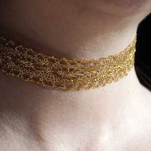 May include: A gold crochet choker necklace. The necklace is made of a delicate, intricate pattern and is perfect for adding a touch of elegance to any outfit.