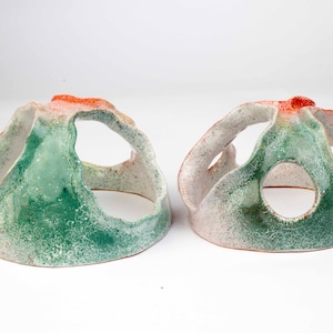 Könnte beinhalten: Zwei kuppelförmige Keramik-Pflanzer mit einer grünen, weißen und orangefarbenen Glasur. Die Pflanzer haben mehrere Öffnungen und eignen sich perfekt zum Ausstellen kleiner Pflanzen.