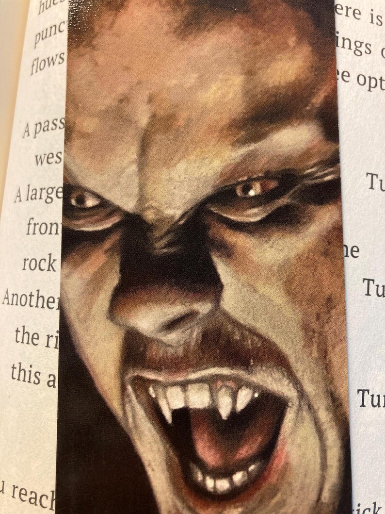 May include: A bookmark featuring a detailed, close-up illustration of a vampire's face. The artwork showcases a snarling expression with sharp fangs, intense eyes, and a dramatic, dark color palette. The bookmark is designed for book lovers.
