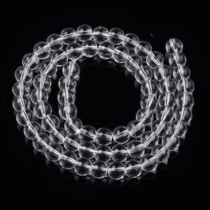 May include: A necklace of clear quartz crystal beads. The beads are spherical and transparent, threaded to form a continuous loop. The beads are uniformly sized and reflect light, creating a sparkling effect. The background is black, which highlights the clarity of the quartz.