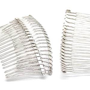 May include: Two silver metal hair combs. Each comb features a series of thin, straight tines attached to a decorative, twisted base. The combs are designed for securing hair and are set against a white background.