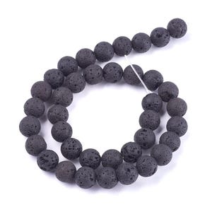 May include: A strand of black lava rock beads. The beads are round and have a rough, textured surface.