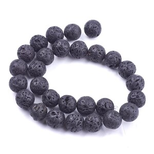 May include: A strand of black lava rock beads. The beads are round and have a rough, textured surface.
