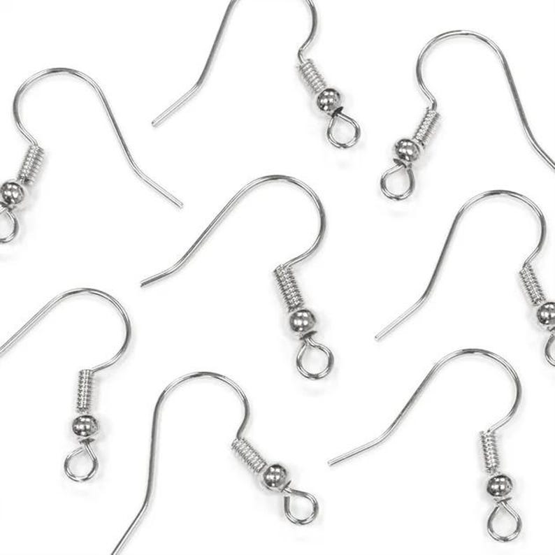 May include: A collection of silver-colored earring hooks, displayed against a white background. Each hook features a curved wire design with a coil and a small bead, and a loop at the bottom for attaching earrings. The hooks are designed for jewelry making.