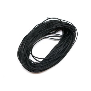 May include: A coil of black waxed cord, a type of string used for crafts and jewellery making.
