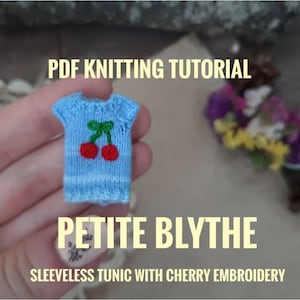 May include: A miniature blue knitted sleeveless tunic with cherry embroidery. The tunic is designed for a Petite Blythe doll. The image also includes the text "PDF Knitting Tutorial" and "Petite Blythe" and "Sleeveless Tunic with Cherry Embroidery".