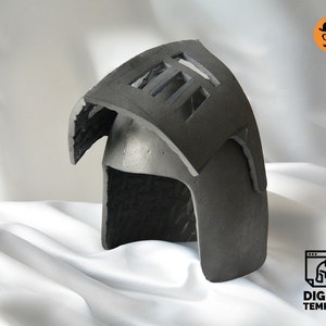 May include: A dark gray helmet with a rectangular opening on top and a curved visor. The helmet is made of a textured material and sits on a white cloth. The image includes a logo that says "DIGITAL TEMPLATE".
