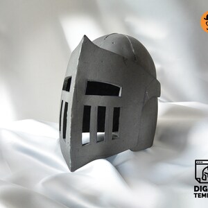 May include: A gray medieval knight helmet with a visor featuring vertical slits. The helmet has a rounded top and a pointed crest. The image includes a logo that says "DIGITAL TEMPLATE".