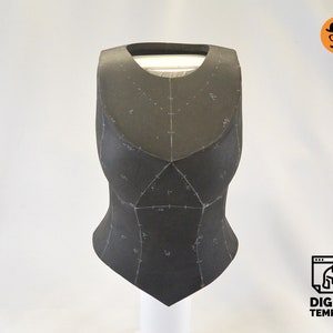 May include: A black foam template for a costume piece, with markings and lines drawn on it. The template is shaped like a vest or bodice.