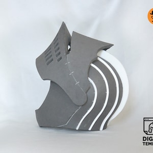 Puede incluir: Un casco de espuma gris con detalles de espuma blanca. El casco tiene un dise&ntilde;o segmentado con costuras visibles. El casco est&aacute; dise&ntilde;ado para cosplay o la fabricaci&oacute;n de utiler&iacute;a.