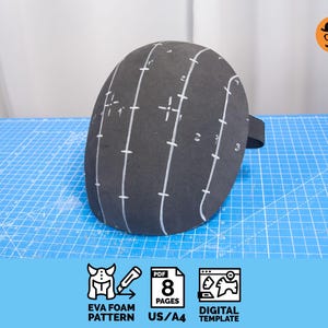 Puede incluir: Un patrón de espuma EVA negro, marcado con líneas y números blancos, se encuentra sobre una esterilla de corte azul. El patrón incluye una correa negra. La imagen también incluye iconos para "EVA Foam Pattern", "PDF 8 Pages" y "Digital Template".