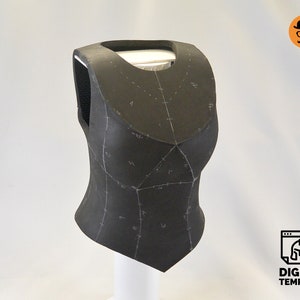 May include: A black foam armour piece with markings for sewing. The armour is shaped like a vest and has a pointed bottom.