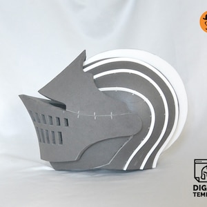 Puede incluir: Un casco de espuma gris y blanco con visera y superficie texturizada. El casco est&aacute; dise&ntilde;ado para ser utilizado como accesorio o disfraz.