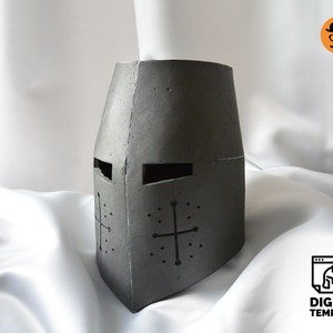 May include: A gray, medieval-style helmet with a cross design on the front. The helmet has eye slits and is made of a textured material. The image also includes a digital template logo.
