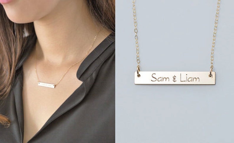Puede incluir: Collar de barra dorado con los nombres "Sam & Liam" grabados en un colgante rectangular. El collar se muestra en el cuello de una persona, con un primer plano del colgante y la cadena.