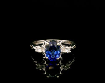 Anillo trilogía de zafiros cultivados en laboratorio con diseño de banda retorcida y oro blanco de 9 quilates.