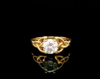 Anillo con circonita cúbica blanca y diseño celta en oro amarillo de 9 quilates.