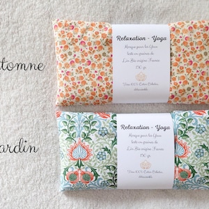 May include: Two rectangular eye pillows with white paper bands. The top pillow features an orange and pink floral pattern labeled Automne. The bottom pillow has a blue, green, and orange botanical print labeled Jardin. Both include French text.