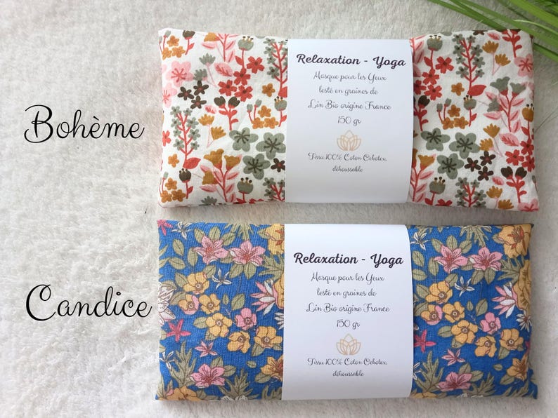 May include: Two rectangular eye pillows with floral patterns. The top pillow has a white background with red, orange, and green flowers. The bottom pillow has a blue background with yellow and pink flowers. Each has a white label reading Relaxation - Yoga.