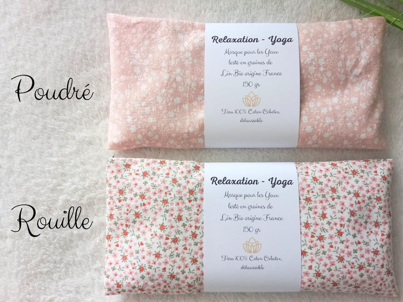 May include: Two rectangular eye masks with floral patterns. The top mask is light pink with white flowers, labeled Poudr&eacute;. The bottom mask has a dense red and green floral print, labeled Rouille. Both feature white paper bands with French text.