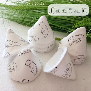 Peut inclure: Plusieurs articles en tissu blanc ornés d'illustrations d'ours polaires noirs. Les articles sont en forme de cône et semblent être faits d'une matière douce. Le texte "Lot de 5 ou 10" est visible. Ils sont disposés sur une surface blanche avec du feuillage vert.