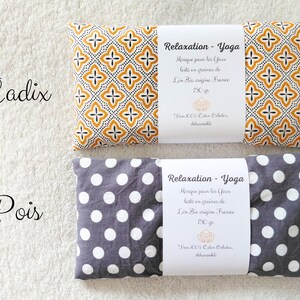 May include: Two rectangular eye pillows with white paper bands. The top pillow features a yellow and black geometric pattern labeled Cadix. The bottom pillow has a gray and white polka dot pattern labeled Pois. Both bands state Relaxation - Yoga, 150 gr.