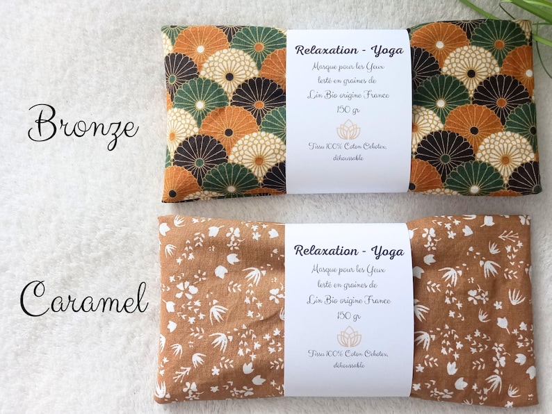 May include: Two rectangular eye masks labeled Relaxation-Yoga. The top mask features a bronze, green, and cream fan pattern. The bottom mask is caramel with a white floral print. Each has a white paper band stating 150g and 100% cotton.
