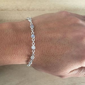 May include: A silver chain bracelet with round moonstone beads.
