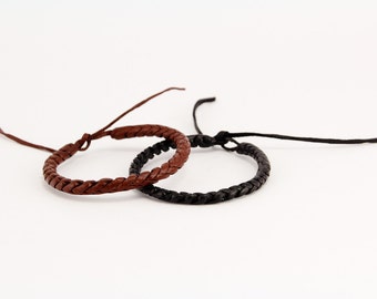 May include: Two braided leather bracelets, one brown and one black.