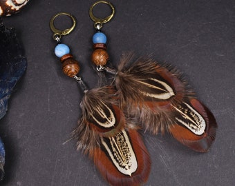 May include: A pair of earrings with brown wooden beads, blue glass beads, and brown and white feathers.