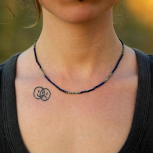 Handgemachte Lapislazuli-Kette mit Türkis-Akzenten auf schwarzem Stoff – filigraner Naturschmuck im Boho-Stil.