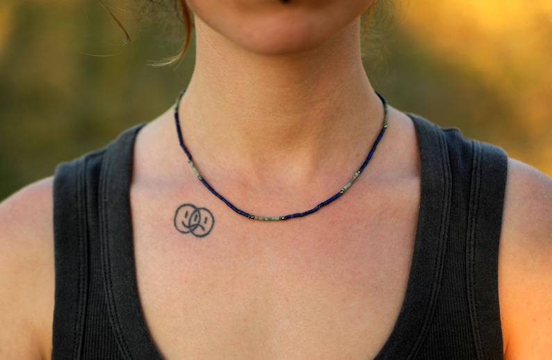 Handgemachte Lapislazuli-Kette mit Türkis-Akzenten auf schwarzem Stoff – filigraner Naturschmuck im Boho-Stil.