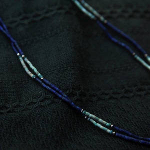 Seitliche Nahaufnahme einer getragenen Lapislazuli-Kette – dezenter, minimalistischer Halsschmuck mit Natursteinperlen.