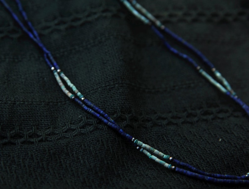 Seitliche Nahaufnahme einer getragenen Lapislazuli-Kette – dezenter, minimalistischer Halsschmuck mit Natursteinperlen.