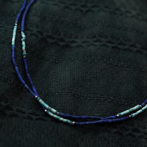 Minimalistische Lapislazuli-Halskette mit Türkis-Elementen, getragen am Hals – handgefertigter Edelsteinschmuck für den Alltag.