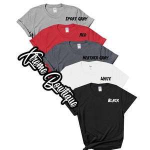 May include: Five t-shirts in different colors: sport gray, red, heather gray, white, and black. Each shirt has a different color text on the front: "Sport Gray", "Red", "Heather Gray", "White", and "Black".