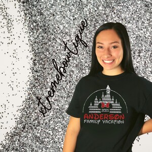 May include: Black t-shirt with a silver glitter design of the Disney castle, a red bow, and the text "2021 Anderson Family Vacation".