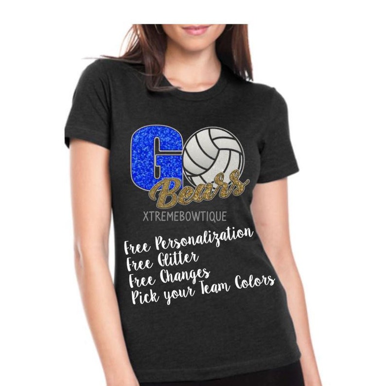 May include: A dark grey t-shirt with a blue and gold glitter design that says "Go Bears" with a volleyball graphic. The text "Free Personalization, Free Glitter, Free Changes, Pick your Team Colors" is printed below the design. The text "XTREMEBOWTIQUE" is printed below the text.