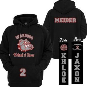 Puede incluir: Sudadera con capucha negra con un gr&aacute;fico de bulldog y las palabras "WAR DOGS Football & Cheer". La parte trasera muestra el nombre "MEIDER". El n&uacute;mero "2" est&aacute; en la parte delantera. Gr&aacute;ficos de brazo incluyen una animadora y un bal&oacute;n de f&uacute;tbol.