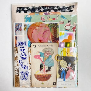 May include: A collection of assorted paper ephemera and vintage-style cards sealed in a clear plastic sleeve. The set includes a card labeled 13 Chemist Clyde featuring a cartoon scientist, a strip with the text DRIVE THE RAMS CRAZY, and a card with the text DANCE? featuring two figures in a field.