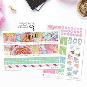May include: A colorful April calendar planner with a carnival theme. The calendar features illustrations of popcorn, ice cream, hot dogs, and a carousel. The planner includes a section for remembering events and a section for a day at the fair. The planner is decorated with glitter and has a real foil accent.
