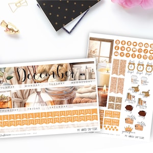 May include: A printable planner sticker sheet with a December calendar and various stickers featuring winter spa-themed illustrations. The stickers are in shades of brown, orange, and gold. The text "My Winter Spa-Scape" is printed on the sheet.