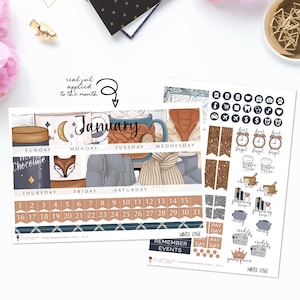 May include: A January calendar planner with a winter theme. The calendar features a cozy illustration of a mug of hot chocolate, a fox, and a winter scene. The planner includes a list of days and dates, as well as a section for remembering events. The planner also includes a set of stickers with winter-themed illustrations and text.