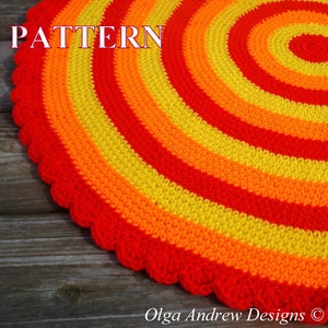 May include: A crocheted round rug with a concentric circle pattern in red, orange, and yellow yarn. The rug has a scalloped edge.