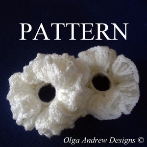 Può includere: Due scrunchies per capelli in crochet bianco con un design a balze. Gli scrunchies sono su uno sfondo blu scuro. Il testo "PATTERN" è nella parte superiore dell'immagine. Il testo "Olga Andrew Designs ©" è nella parte inferiore dell'immagine.